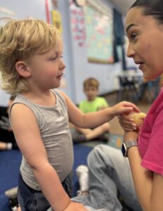 Toddler exploring with a teacher at Loving Touch Nursery School