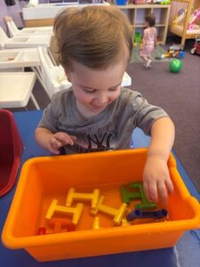 Child exploring a sensory activity in the Munchkins classroom at Loving Touch Nursery School