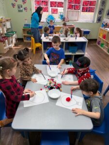 Preschool children exploring science with a teacher at Loving Touch Nursery School